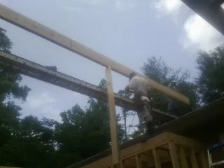 Carpenter setting a ridge beam over a new addition frame — Ice Dam Removal by Roofing Brothers in Park Hills