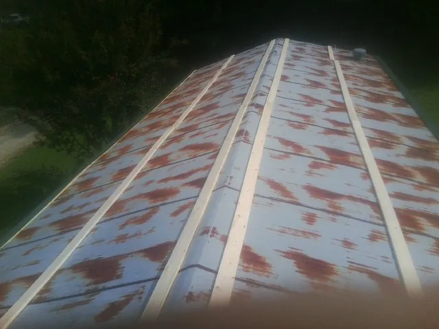 Rusted metal roof panels with new wood purlins before replacement — Storm Damage Roof Repair in Park Hills by Roofing Brothers