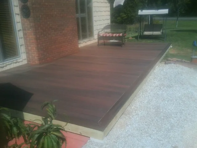 Freshly stained wood deck built against a brick home in Park Hills