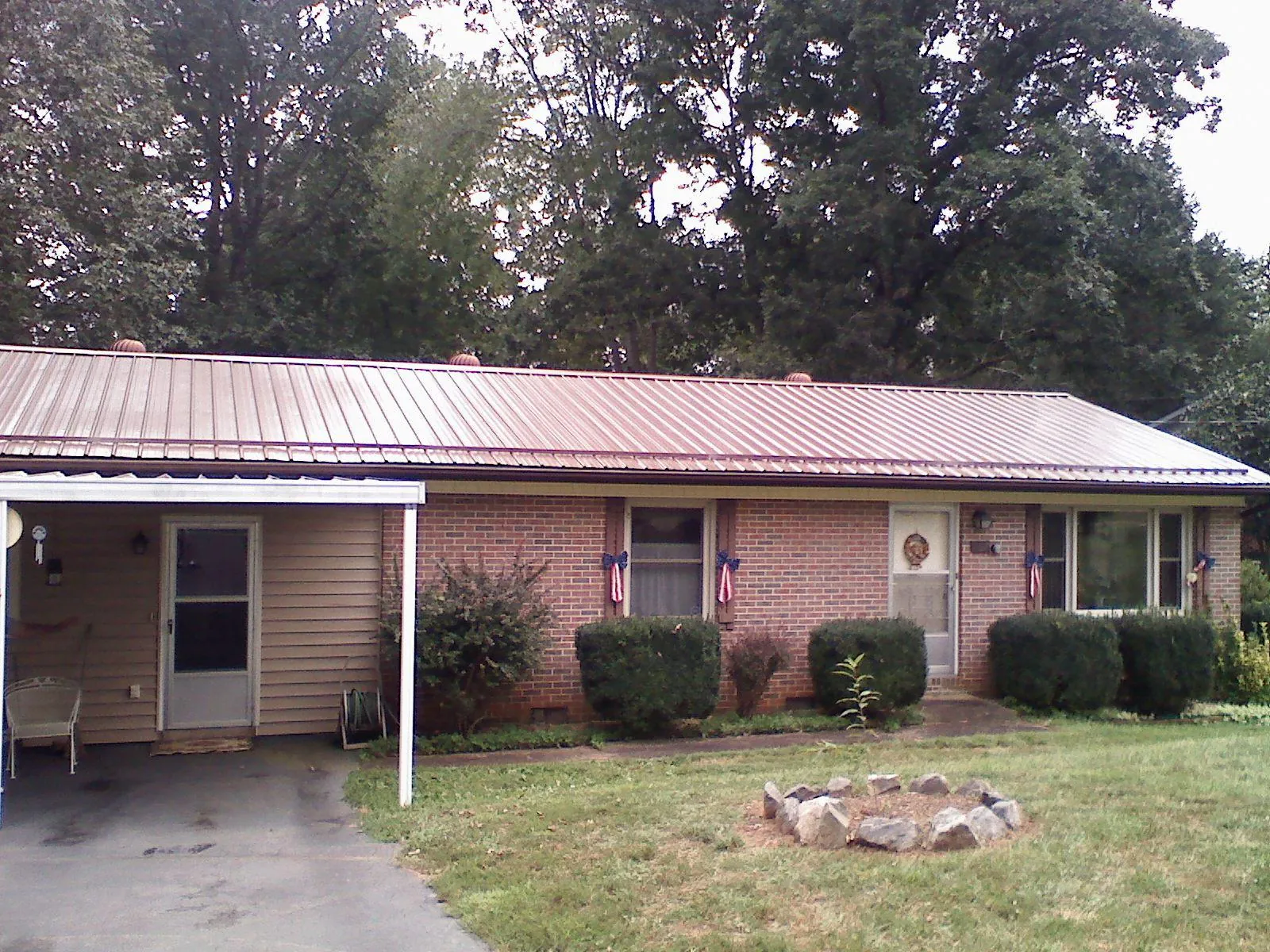 Bronze metal roof and carport on a brick ranch home — Roof Repair work by our crew in Park Hills